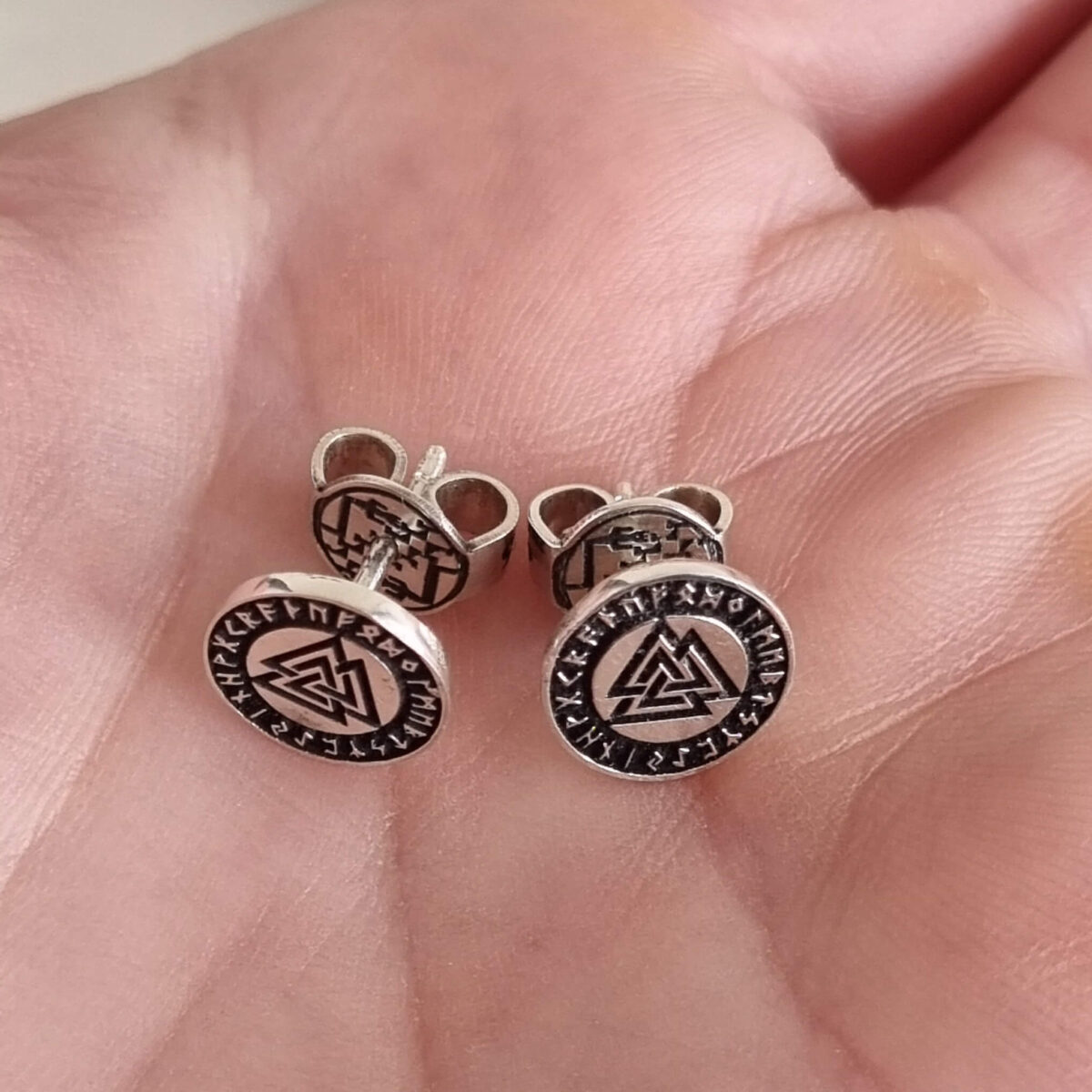 Aros Valknut plata ley 950 de 1 cm sostenidos en la mano, joya artesanal con turcas firmes y diseño nórdico simbólico